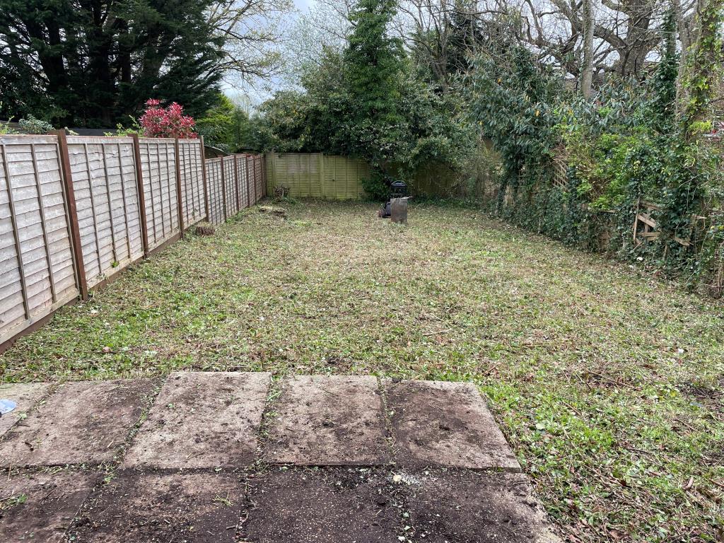 Lot: 127 - HOUSE IN NEED OF REFURBISHMENT AND REPAIR - rear garden with paved patio and fence
